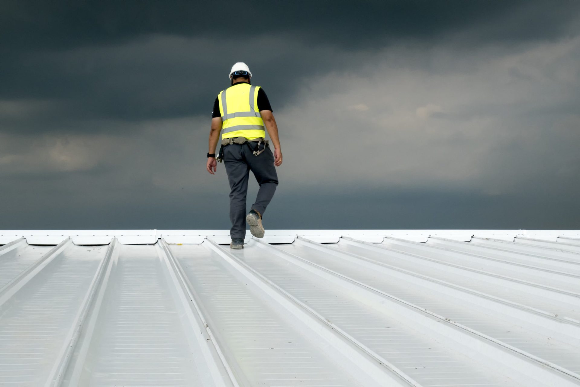 Roofer walking along a corrugated metal roof