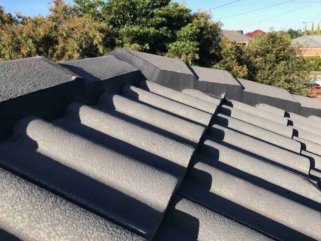 Close-up of a grey concrete tile roof ridge